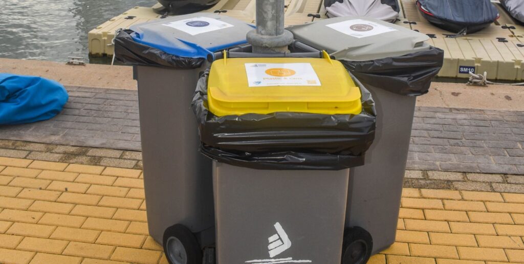 11. Ensure Proper Waste Bin Placement and Signage<br>Four waste management points were distributed between the race office and the race village tent with waste, paper and plastic bins. The days where bottled beer was offered, they were asked to return the bottles at the bar (inside the race village tent) to be proper recycled. It was not possible to include a compostable waste bin as this service is not available in L