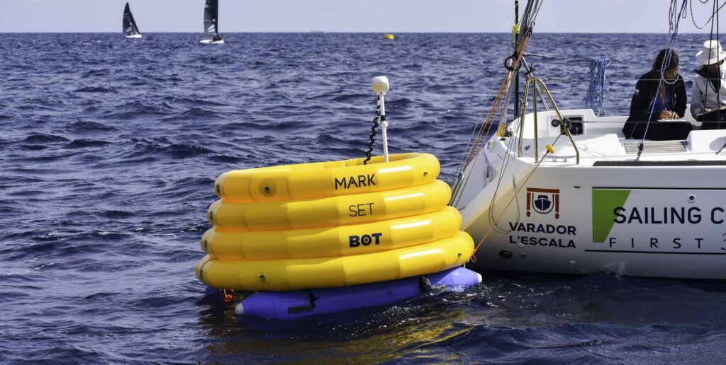 19. Reduce Day-of Emissions<br>During the RS21 World Championship, we implemented several measures to reduce day-of emissions and minimize the environmental impact of the event.

Robotic Buoys: We utilized a set of Mark Set Bot robotic buoys, which are powered by electric motors and positioned using GPS technology. This innovative approach significantly reduced emissions by minimizing the need for motorboats to place and adjust traditional buoys. Additionally, these robotic buoys do not require anchoring, thereby preventing any impact on the seabed.

Electric Motors in RS21 Boats: The RS21 boats used in the championship are equipped with electric motors. This feature allows the boats to operate without emitting harmful pollutants when not sailing, further contributing to the reduction of overall emissions during the event.

By incorporating these technologies, we aimed to create a more sustainable and environmentally friendly regatta, aligning with our commitment to reducing the carbon footprint of our activities.