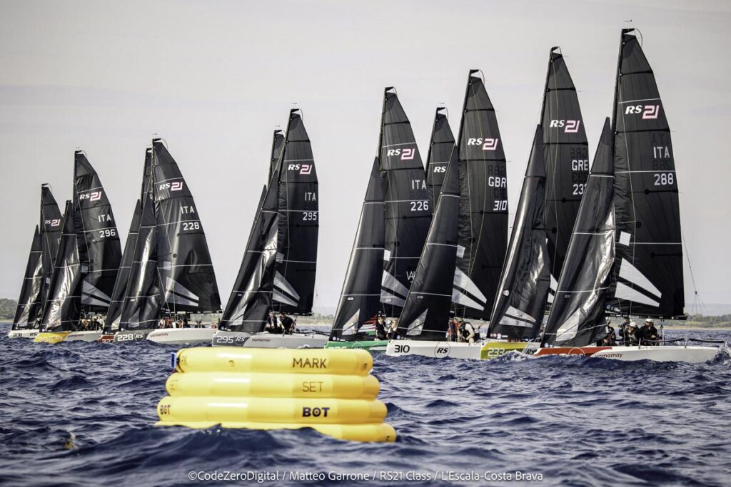 19. Reduce Day-of Emissions<br>During the RS21 World Championship, we implemented several measures to reduce day-of emissions and minimize the environmental impact of the event.

Robotic Buoys: We utilized a set of Mark Set Bot robotic buoys, which are powered by electric motors and positioned using GPS technology. This innovative approach significantly reduced emissions by minimizing the need for motorboats to place and adjust traditional buoys. Additionally, these robotic buoys do not require anchoring, thereby preventing any impact on the seabed.

Electric Motors in RS21 Boats: The RS21 boats used in the championship are equipped with electric motors. This feature allows the boats to operate without emitting harmful pollutants when not sailing, further contributing to the reduction of overall emissions during the event.

By incorporating these technologies, we aimed to create a more sustainable and environmentally friendly regatta, aligning with our commitment to reducing the carbon footprint of our activities.