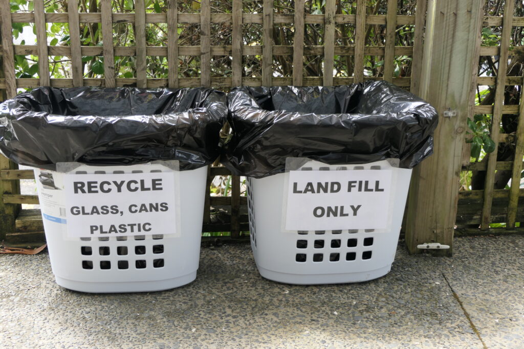 11. Ensure Proper Waste Bin Placement and Signage<br>11. Cardboard boxes housing beverages, food, and supplies were flattened and placed in a designated reclamation bin. (Photo 11a) Smaller WOWW-specific waste bins were created and placed in appropriately-marked baskets in more than one location for transfer to bigger bins for waste management pick up. (Photo 11b) Bottle caps were sorted in the kitchen and at the bar for club recycling or local school fundraising. (Photo 11c)  