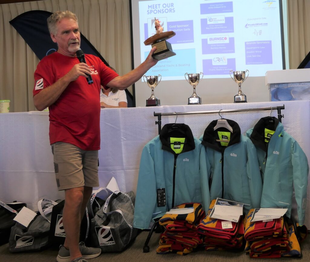 5. Award Practical Items or Use a Perpetual or Upcycled Trophy<br>5. At Prizegiving, WOWW gives out one perpetual trophy for each of the three divisions. Each winning skipper got a wet weather jacket and all of the crew got a beach towel. The second and third placed skippers each got a gear bag (left of Photo 5b)) with some goodies inside. All prizes are usable, wearable or consumable (food or drink) so nothing plastic or gimmicky.
