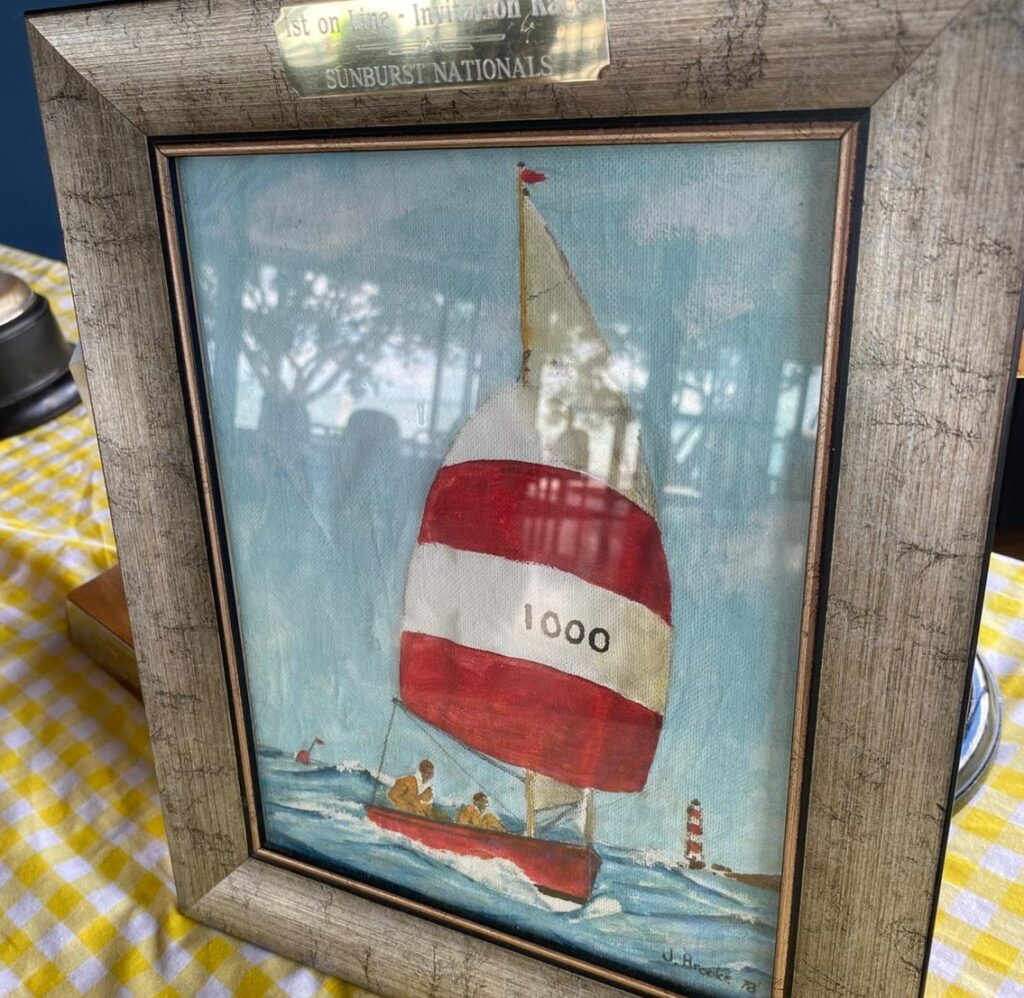 5. Award Practical Items or Use a Perpetual or Upcycled Trophy<br>There are several ways we did this and aimed to keep it fun and meaningful. A duck is handed out every year to someone with a funny story from the regatta. There was also a special painting which was awarded to the winners of the invitation race. 
Medals from the previous sunburst nationals which were held at Wakatere (in 2017) which had been sitting in cupboards were handed to the young competitors, along with leftover T-shirts. This meant no new t-shirts were being made, and instead we were recycling existing stock. 
Plenty of hats for all competitors too - vital for sailors! 