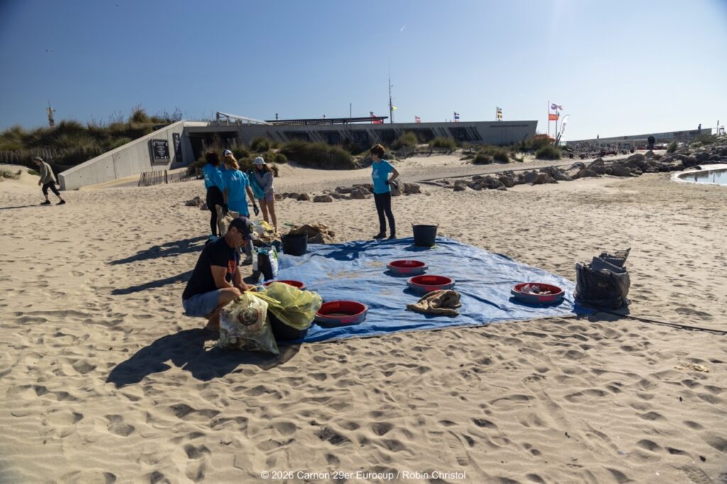 14. Host a Beach or Marina Cleanup<br>14 - We organized a beach clean-up with Ocean Protection France, involving volunteers and members of the public outside the regatta.
We also organized a dedicated clean-up action with the young sailors during a no-wind break. This was a great success and created a strong collective moment.
Initially, we had planned to let sailors join the Green Brigade at any time during the weekend, take part in a beach clean-up, and enter a photo contest. However, this format proved difficult to combine with the rhythm and timing of the races.
We are now looking for new and innovative ideas for next year to further involve young sailors in environmental action during the event.
