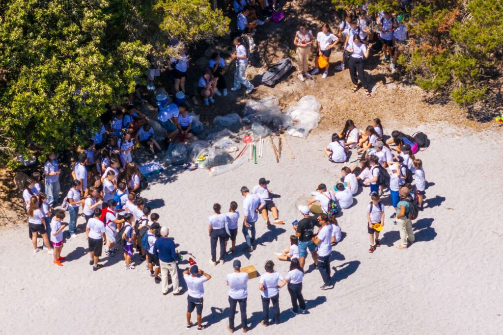 14. Host a Beach or Marina Cleanup<br>A Clean Beach Day was organised the day after the final prize-giving, on June 8th the World Ocean Day, as part of the YCCS sustainability initiatives. Around 100 participants, including some 80 students from the lower secondary schools of Arzachena attended and the event had the patronage of the Municipality of Arzachena – as part of its AgendaBlu 2026 calendar – and carried out in collaboration with the National Research Centre (CNR) of Oristano and the One Ocean Foundation. Approximately 150 kg of waste were collected. The activity involved the students through an educational session led by the CNR of Oristano, including a short explaination of an educational comic magazine "Carrie" on marine pollution. Drawings made by the participating children were collected, helping to raise awareness among younger generations about the importance of protecting the marine environment.