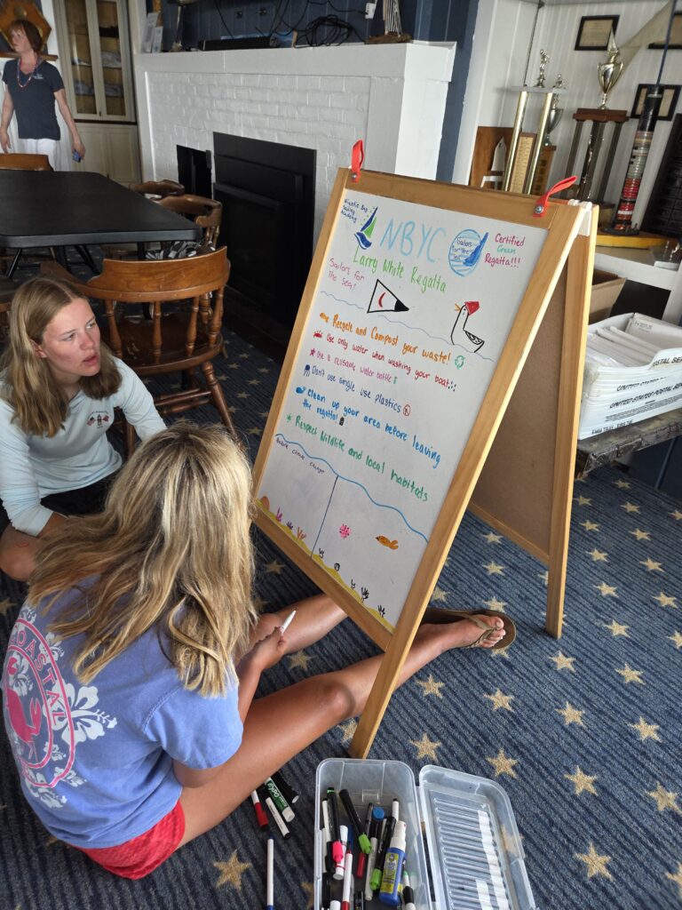 20. Inspire Future Action<br> The Clean Regatta mission has gained traction so that Sailors for the Sea practices are becoming a natural expectation. In the future we are hoping to begin certifying fleets. Above Is a picture of Olivia and Kennedy working on an educational sign used at the regatta. 