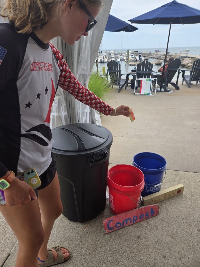 11. Ensure Proper Waste Bin Placement and Signage<br>Signs for trash, compost, and recycling were made from old optimist centerboards and scrap wood found in the water. 