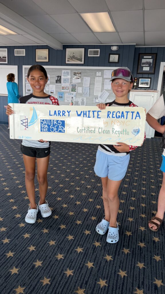 8. Post Educational and Reusable Signage<br>Youth green team members Olivia Murin and Kennedy Nemec created a colorful sign on a whiteboard that lists clean regatta practices. Kids from beginner sailing classes at NBSA also helped to create signage from recycled materials, such as old optimist centerboards and scrap wood found in the water. 