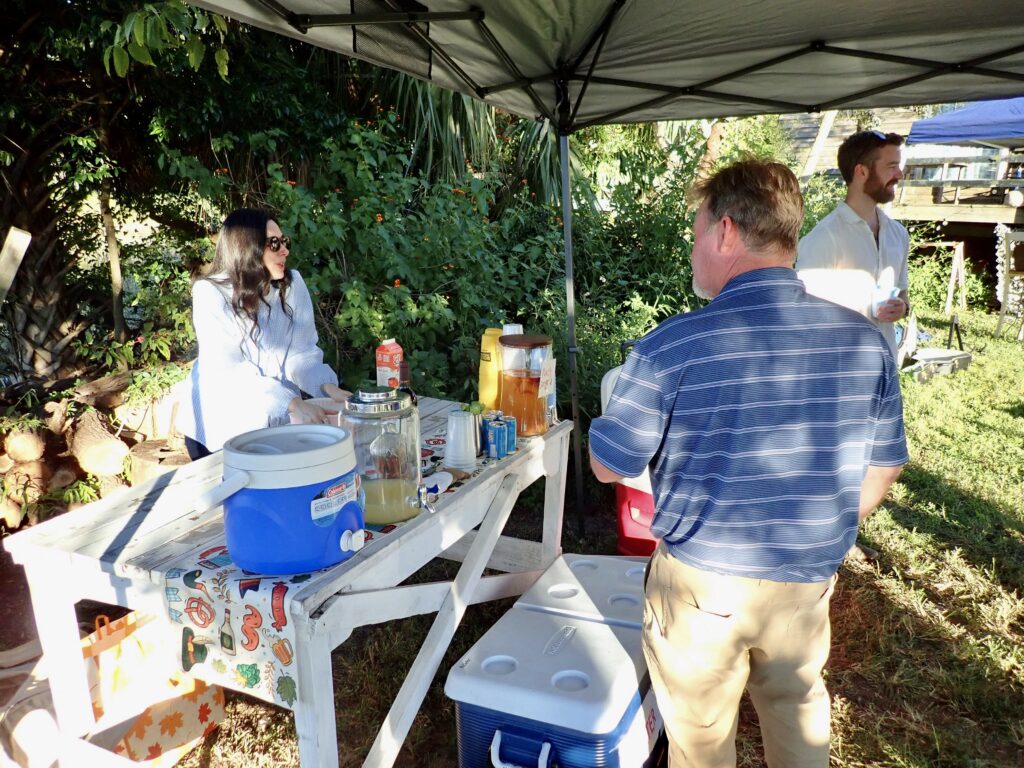 1. Eliminate Single-Use Water Bottles and Provide Water Refill Stations<br>We do not use single use water bottles at all and encourage all boats to have their crews use refillable bottles. We do provide water at our event on land. The small blue jug at the end of the drink table is for water (we did put a sign on it after I took this picture.)