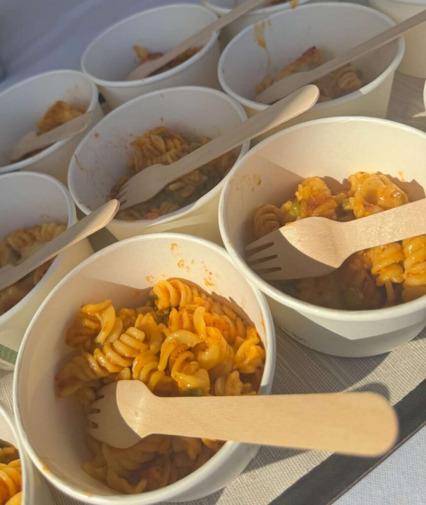 9. Serve Local Food or Source Seafood Sustainably<br>During the event, local food was served, including pasta, pizza and rice dishes prepared with locally sourced vegetables, as shown in the attached photos.